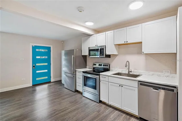 a kitchen with stainless steel appliances a refrigerator sink and stove top oven