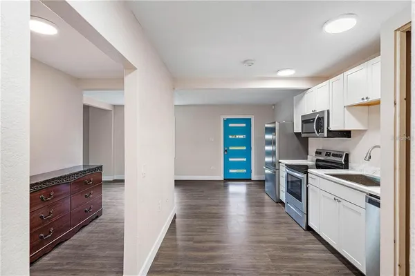 an empty room with wooden floor & windows