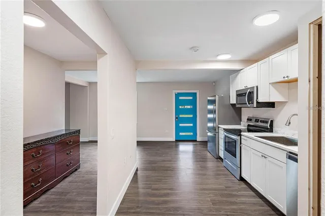 an empty room with wooden floor & windows