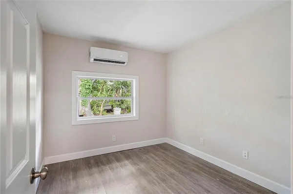 a view of empty room with wooden floor