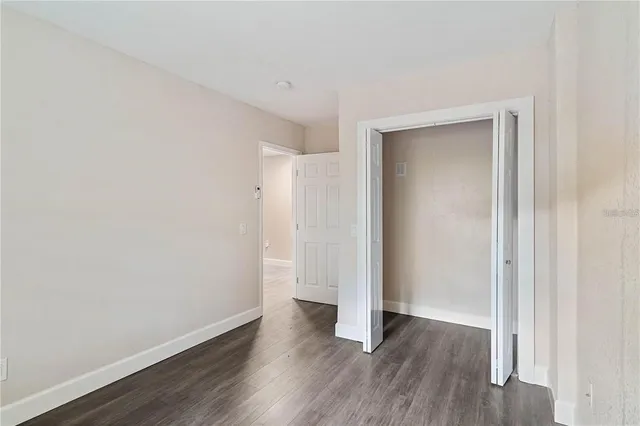 a view of a white house with a big yard and large trees