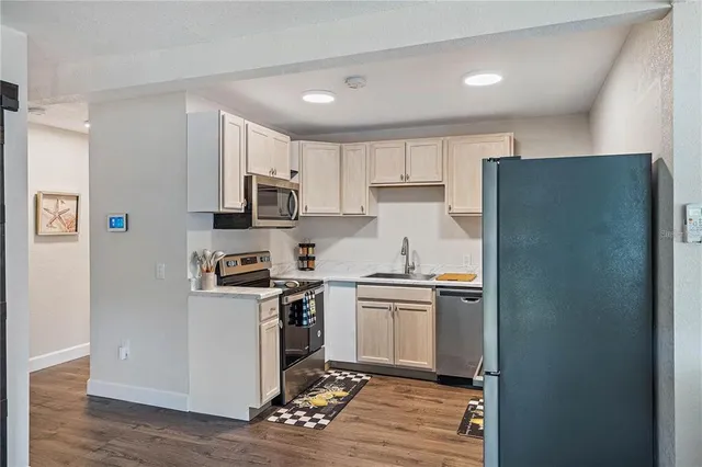 a kitchen with stainless steel appliances granite countertop a refrigerator stove and white cabinets