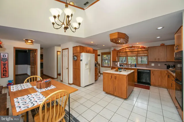 a kitchen with stainless steel appliances granite countertop a stove a sink dishwasher and a refrigerator with wooden floor