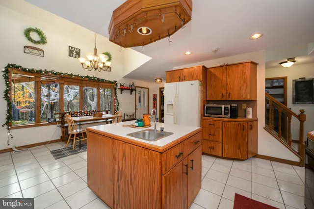 a kitchen with stainless steel appliances granite countertop a sink and a refrigerator