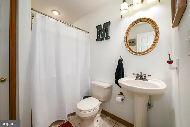 a bathroom with a sink toilet and a mirror