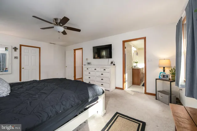 a spacious bedroom with a bed and a flat screen tv