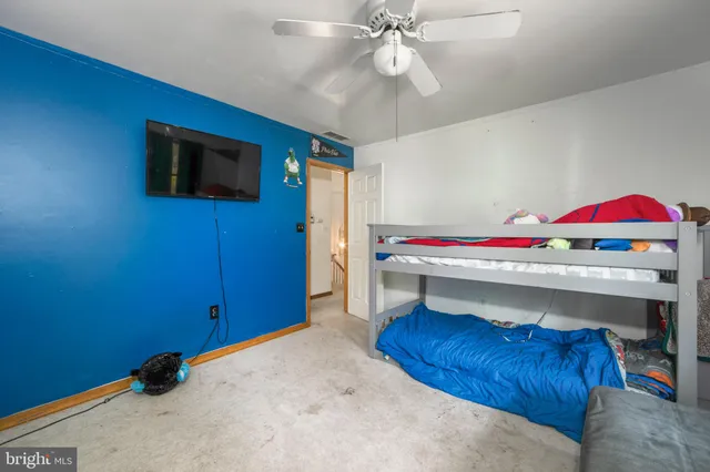 a living room with a bed and a flat screen tv