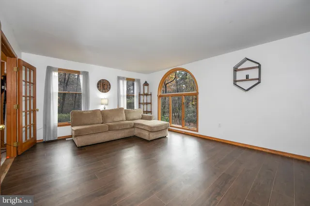 a living room with couches and a large window with wooden floor