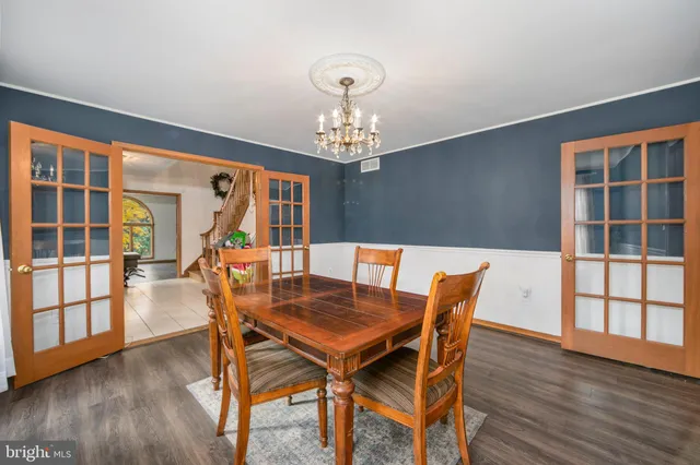 a dining room with furniture a chandelier and wooden floor
