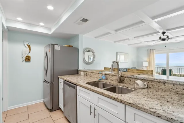 a kitchen with stainless steel appliances granite countertop a sink and a refrigerator