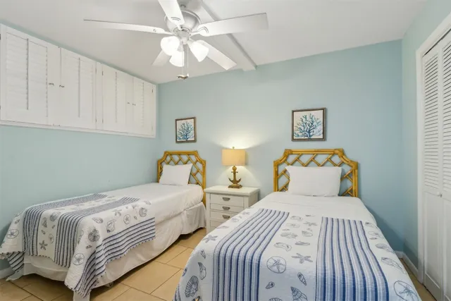 a bedroom with two beds and a chandelier