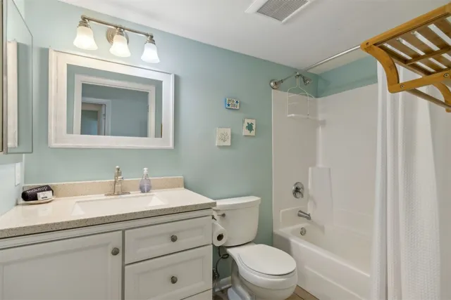 a bathroom with a sink a mirror a toilet and shower