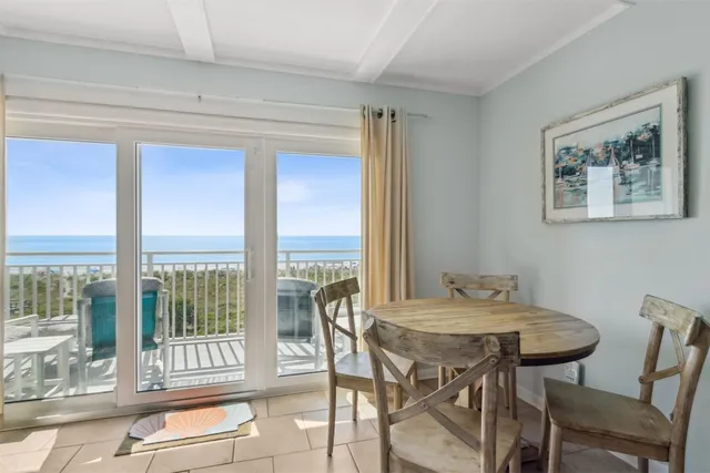 a view of a dining room with furniture large windows and wooden floor