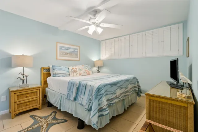 a bedroom with a bed and a tv on the dresser
