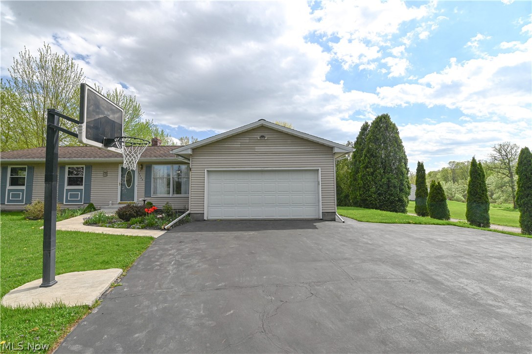 Ranch-style house featuring a front yard and a garage
