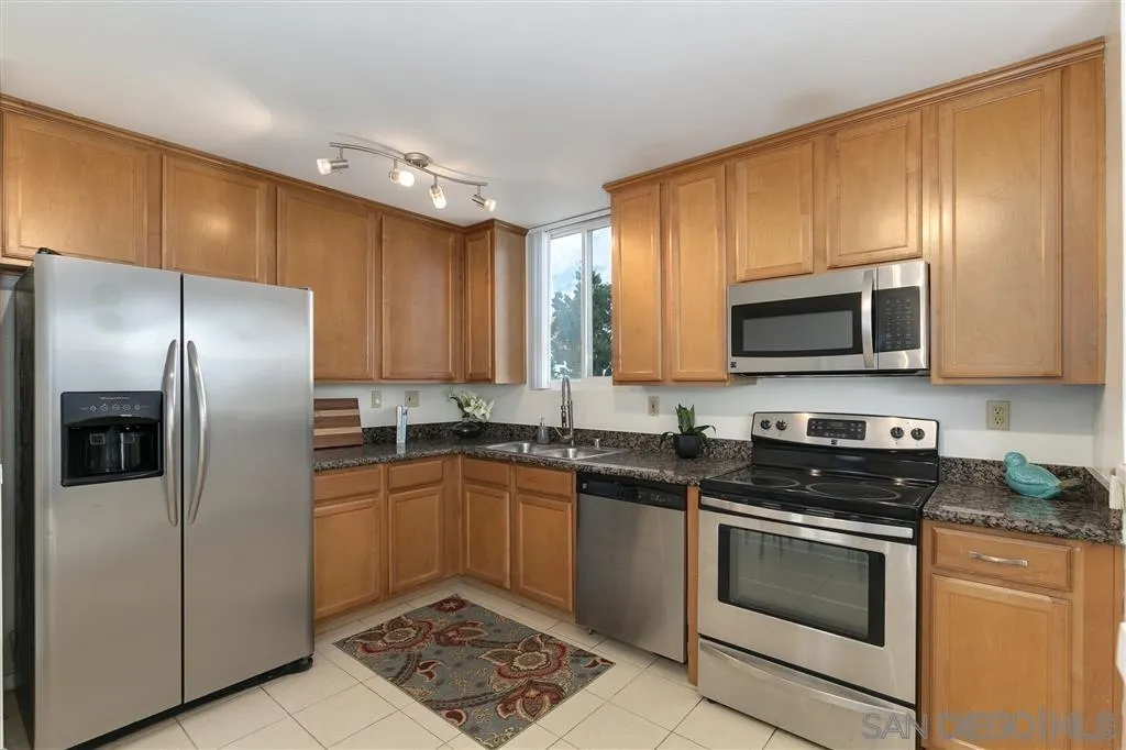 6555 Mt Ada Road, Unit 222 San Diego, CA 92111 - Photo 5 of 12 a kitchen with stainless steel appliances granite countertop a stove a sink dishwasher a refrigerator and a microwave