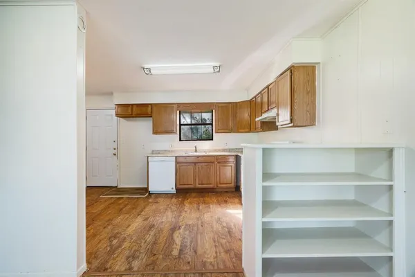 a kitchen with a sink dishwasher a stove and a refrigerator with wooden floor