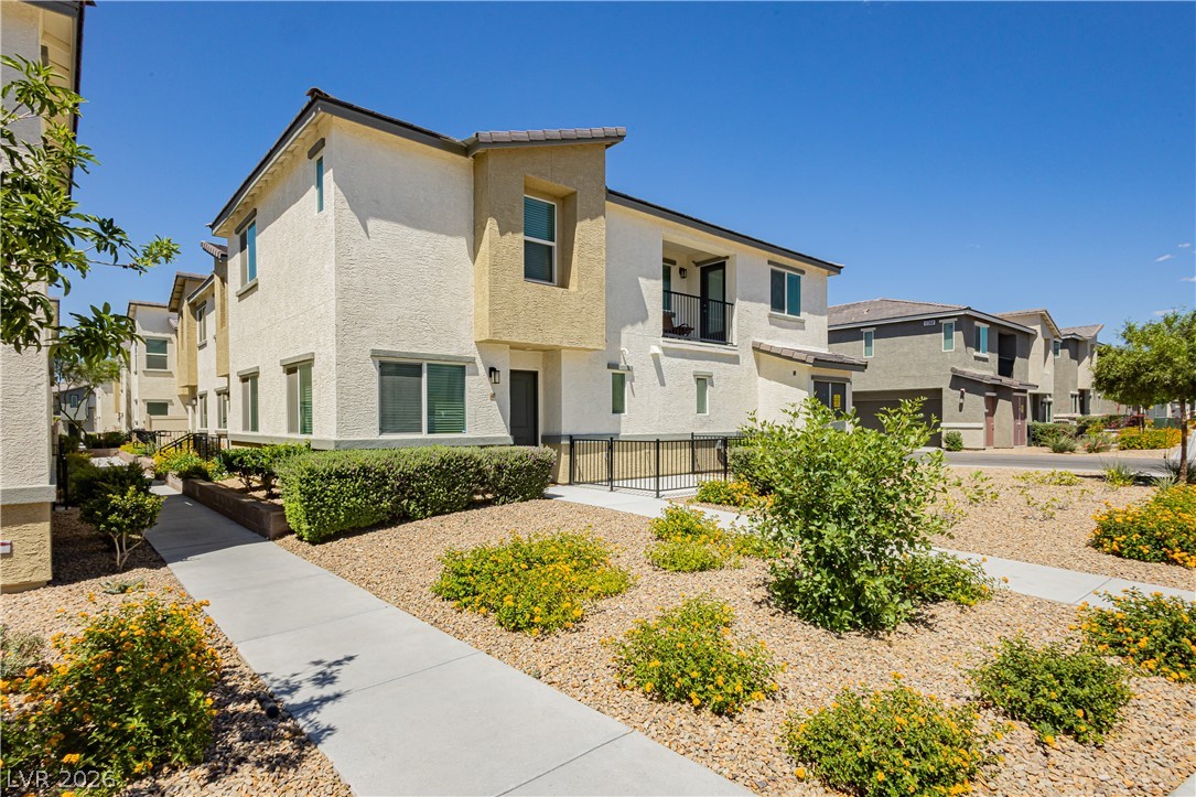 12369 Golden Wreath Road, Unit 2 Las Vegas, NV 89183 - Photo 1 of 19 The townhome's facade is accented by a small balcony and a neatly trimmed hedge.