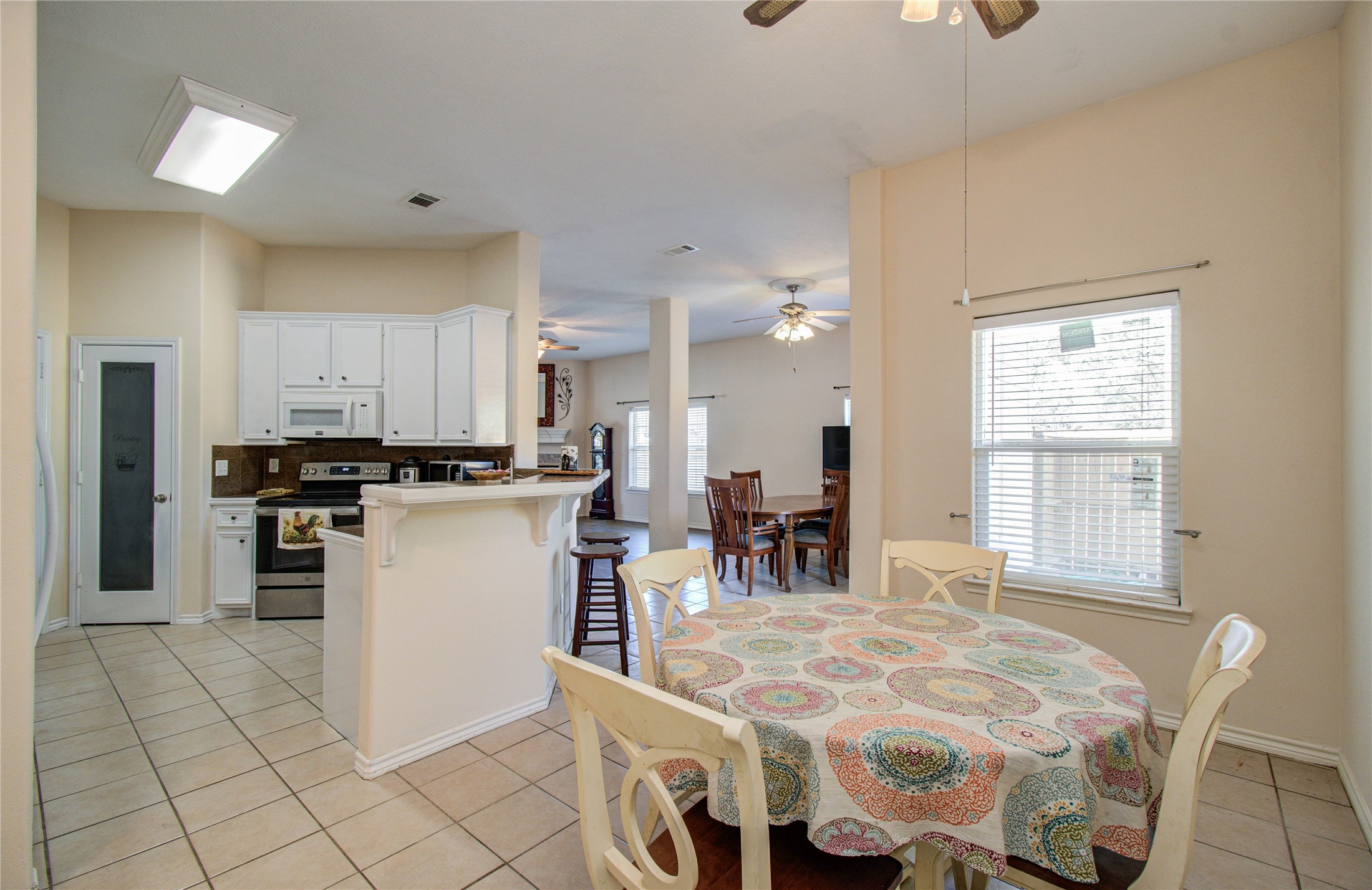 10822 Sail View Street Montgomery, TX 77356 - Photo 16 of 29 a kitchen with a dining table chairs and refrigerator