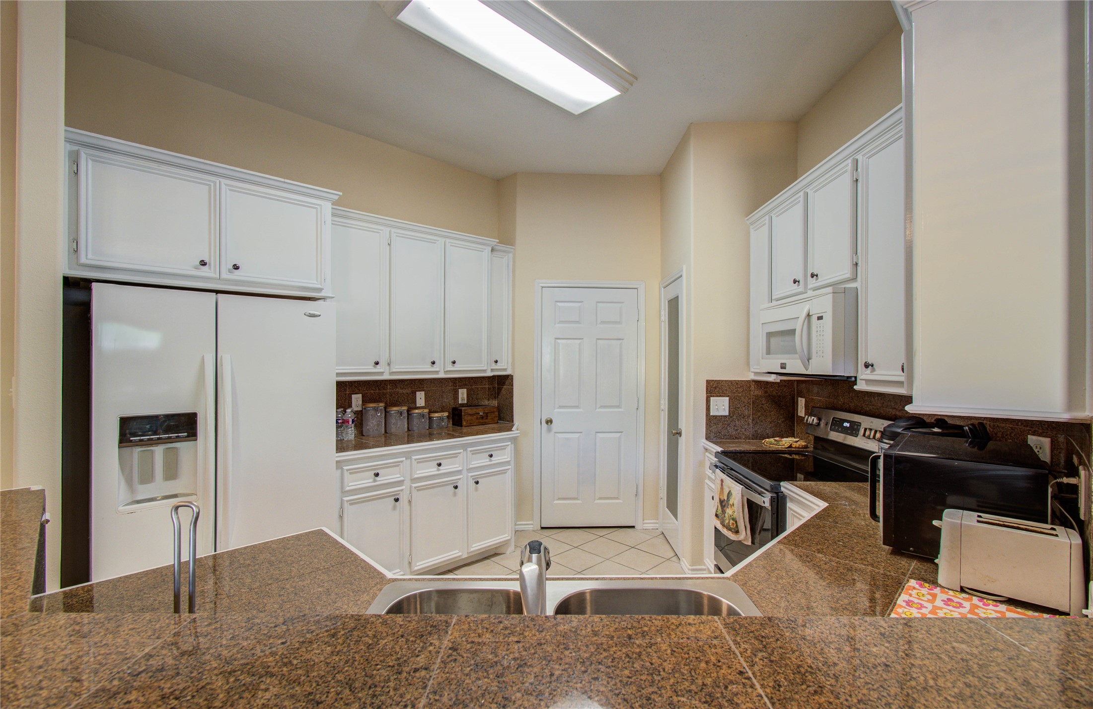 10822 Sail View Street Montgomery, TX 77356 - Photo 19 of 29 a kitchen with stainless steel appliances kitchen island granite countertop a refrigerator stove top oven and sink