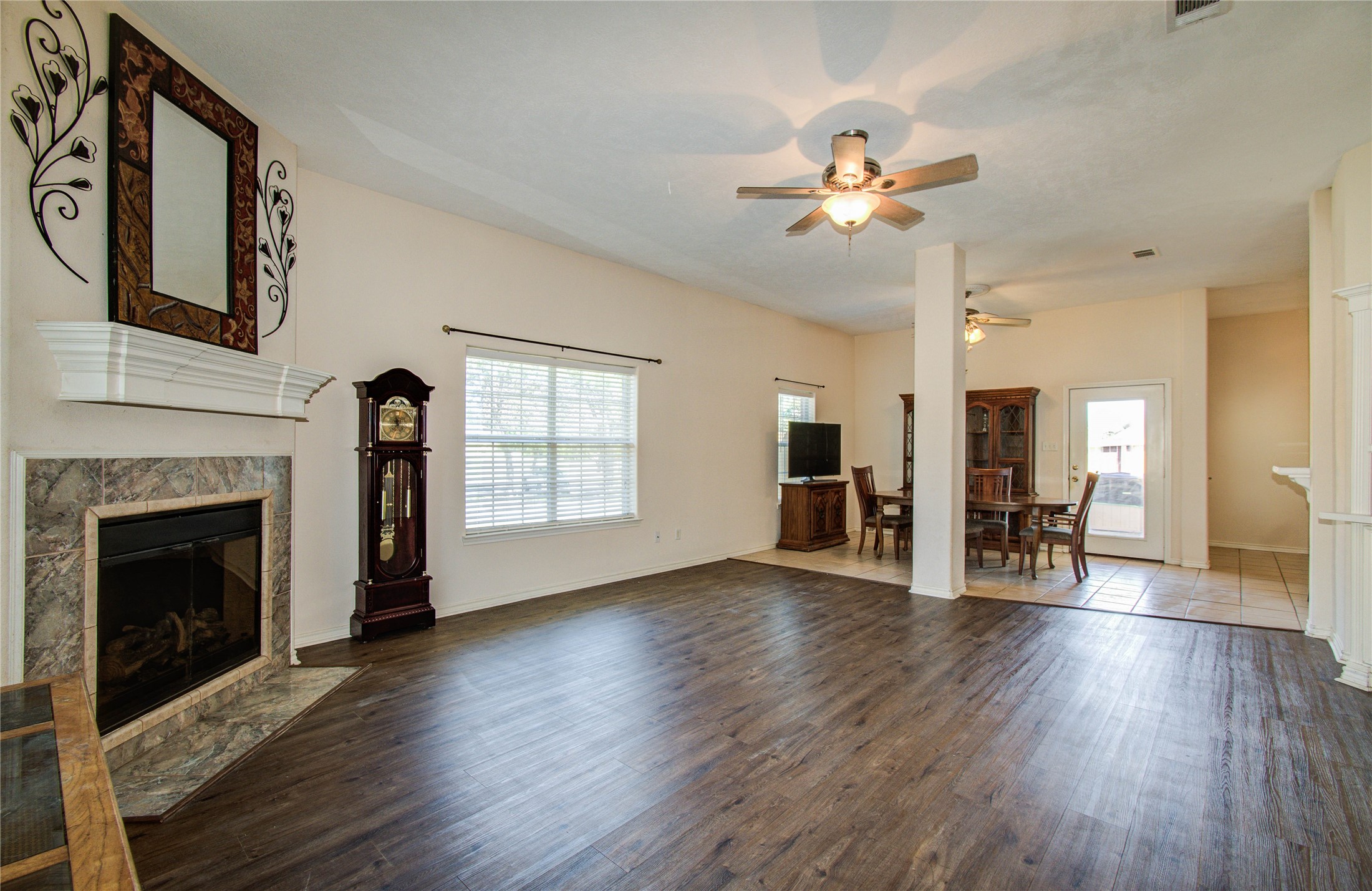 10822 Sail View Street Montgomery, TX 77356 - Photo 6 of 29 a view of an empty room with wooden floor fireplace and a window