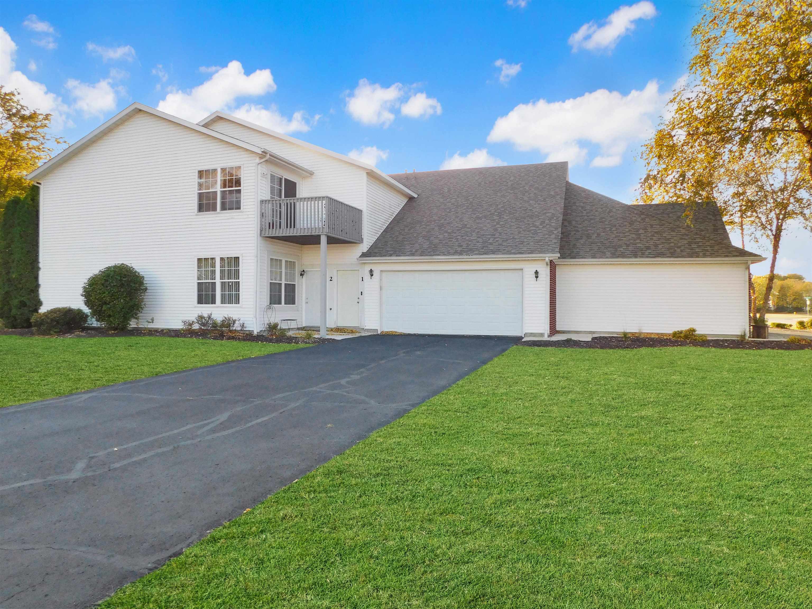 558 Mosaic Lane, Unit 1 Roscoe, IL 61073 - Photo 1 of 28 a view of a white house next to a yard and large trees
