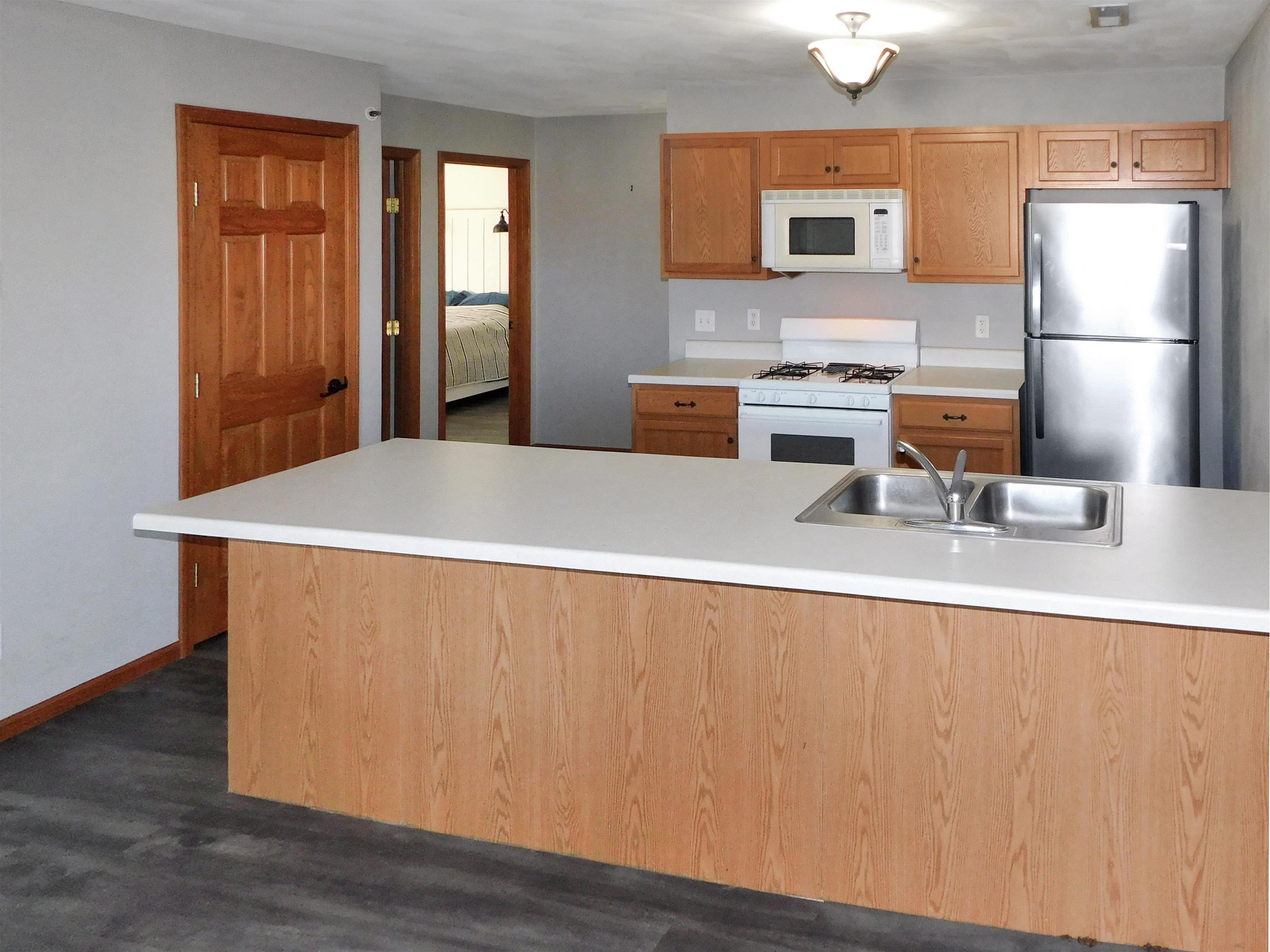 558 Mosaic Lane, Unit 1 Roscoe, IL 61073 - Photo 13 of 28 a kitchen with a refrigerator a stove top oven a sink and dishwasher