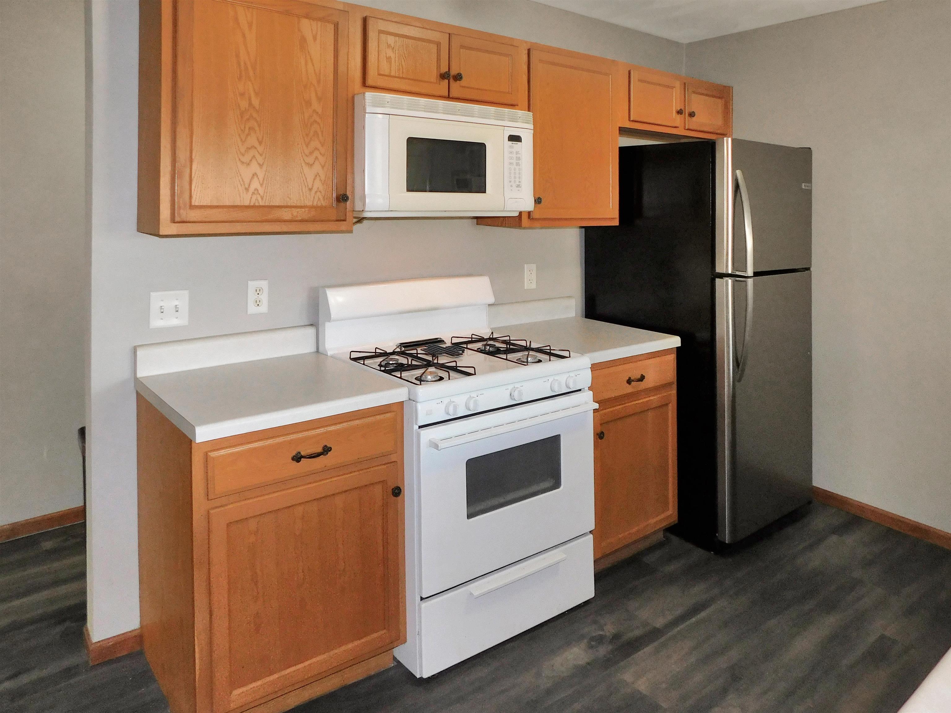 558 Mosaic Lane, Unit 1 Roscoe, IL 61073 - Photo 16 of 28 a kitchen with granite countertop white cabinets and stainless steel appliances
