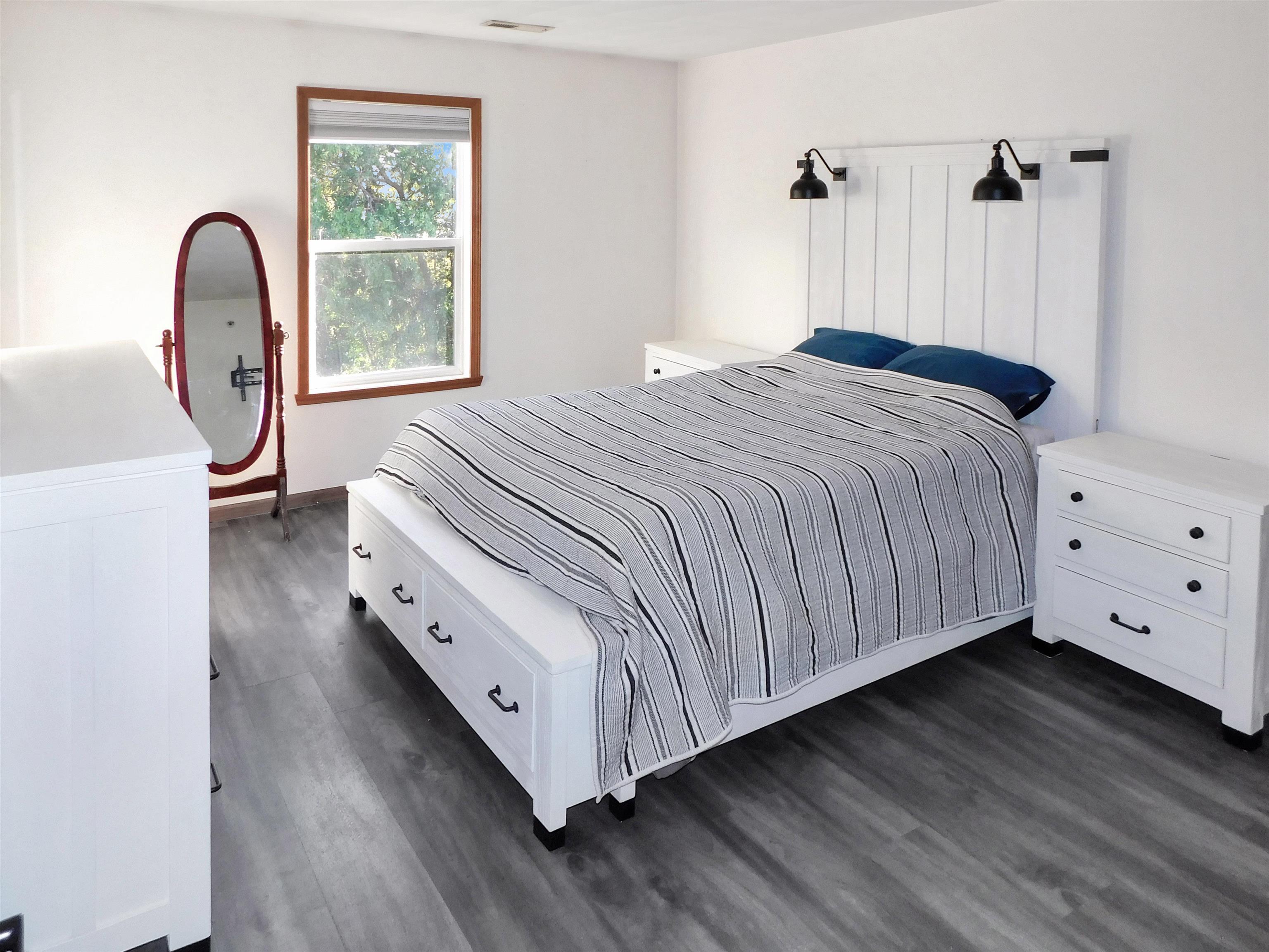 558 Mosaic Lane, Unit 1 Roscoe, IL 61073 - Photo 20 of 28 a spacious bedroom with a bed a dresser with wooden floor
