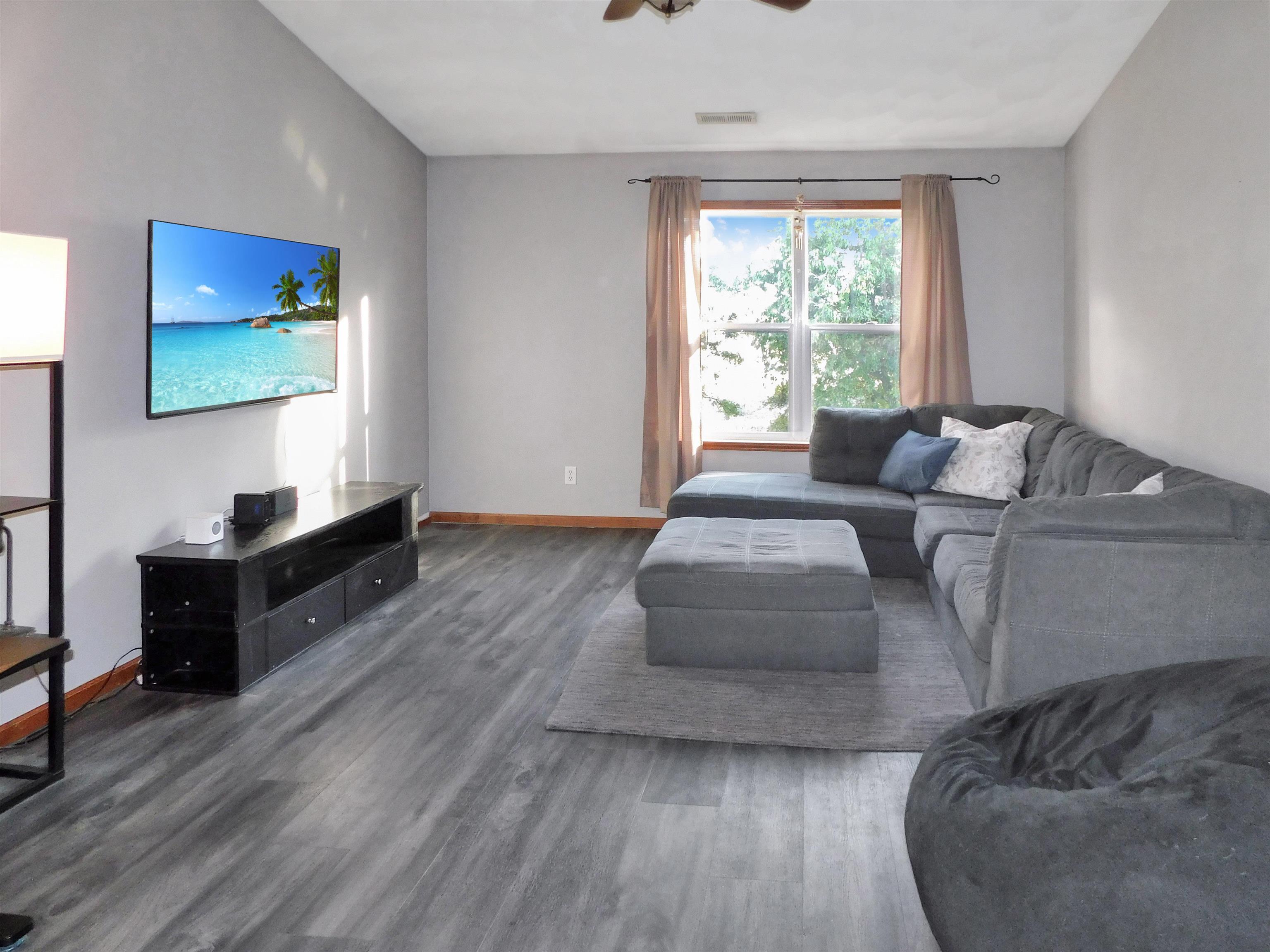 558 Mosaic Lane, Unit 1 Roscoe, IL 61073 - Photo 7 of 28 a living room with furniture and a flat screen tv