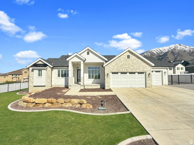 916 Rocky Mountain Way Elk Ridge, UT 84651 - Photo 2 of 54 View of front of house with a garage, stone siding, driveway, board and batten siding, and a residential view