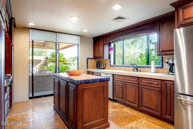 a kitchen with kitchen island granite countertop a sink and a stove