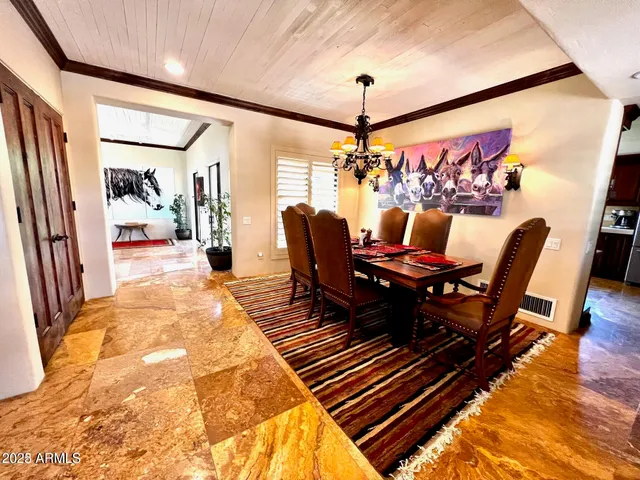 a view of a dining room with furniture a chandelier and wooden floor