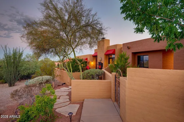 a view of a patio with couches and table and chairs under an umbrella