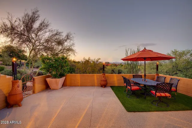 a view of patio with a table and chairs under an umbrella