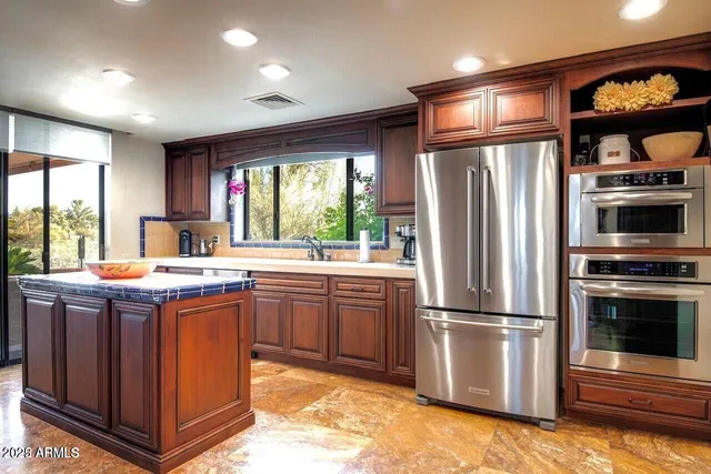 a kitchen with stainless steel appliances granite countertop a refrigerator a stove a sink and a microwave