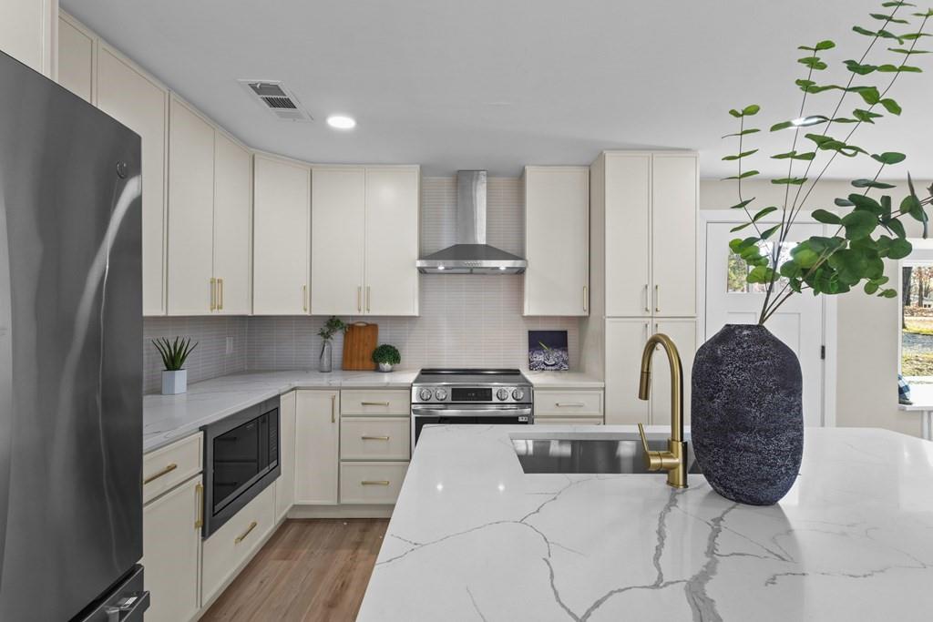 2155 Hickory Trace Mabank, TX 75156 - Photo 13 of 40 a kitchen with stainless steel appliances granite countertop a stove a sink and a refrigerator