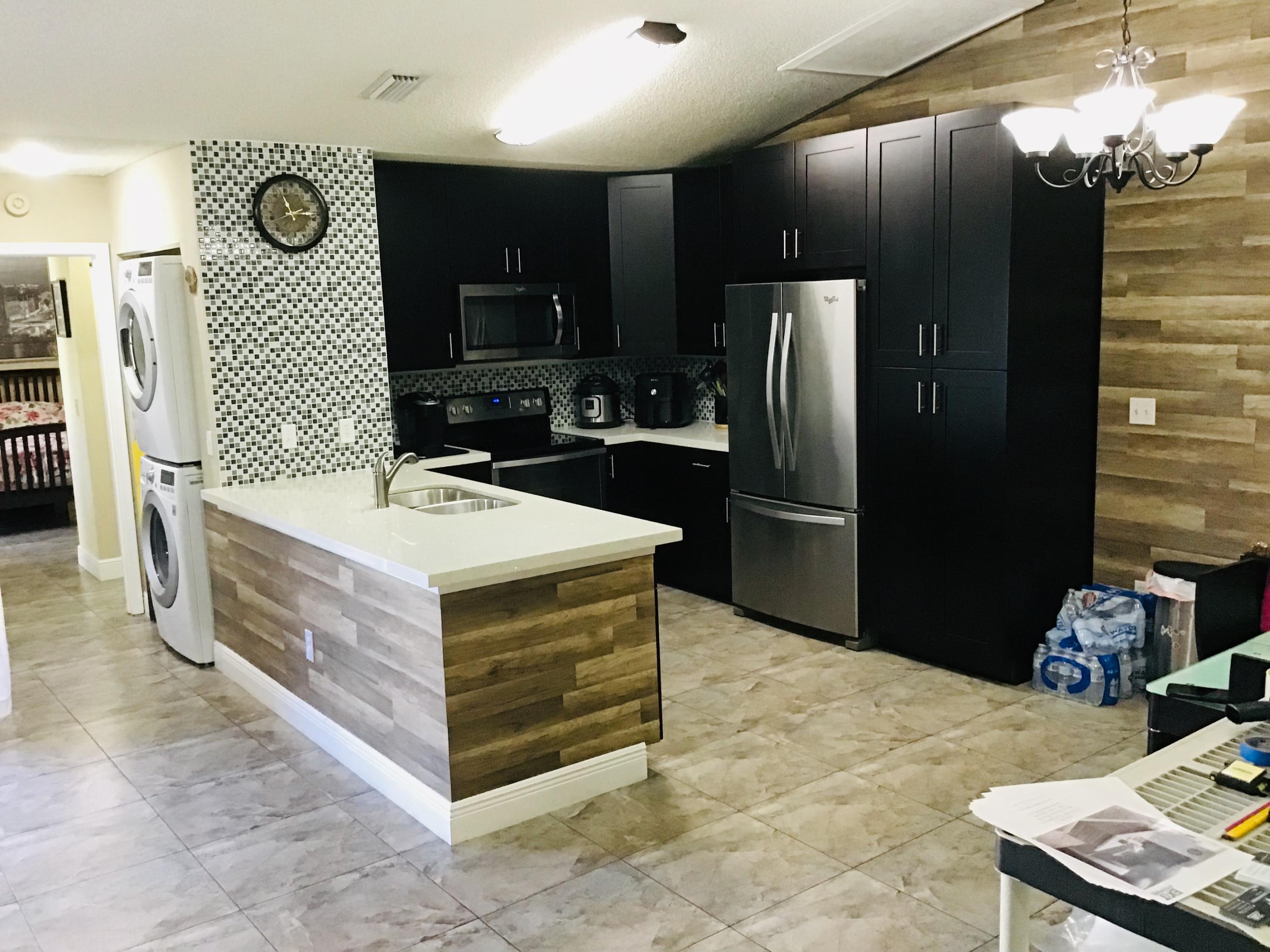 a kitchen with stainless steel appliances kitchen island granite countertop a refrigerator oven a sink and dishwasher