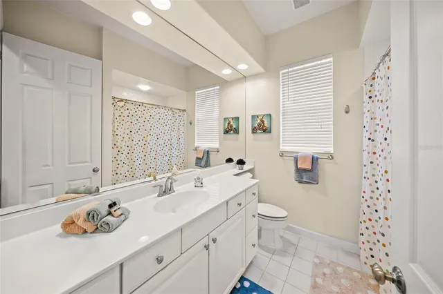 a view of a brick house with a small yard plants and palm trees