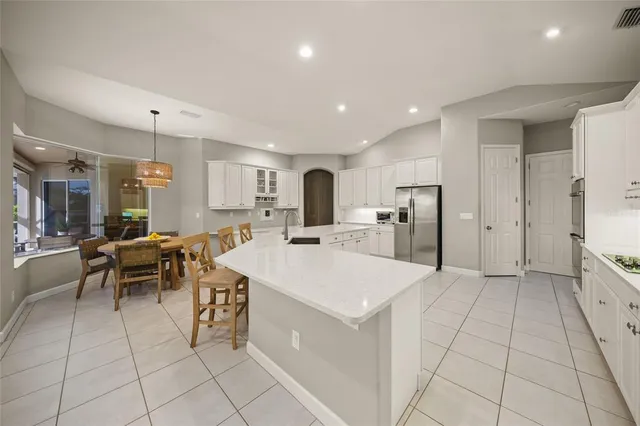 a large white kitchen with a lot of counter space and appliances