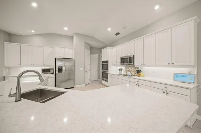 a bathroom with a bathtub a double vanity sink and mirror