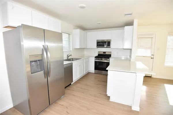 a kitchen with stainless steel appliances a refrigerator and a stove top oven