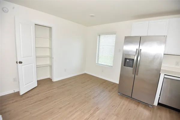 an empty room with wooden floor & closet area