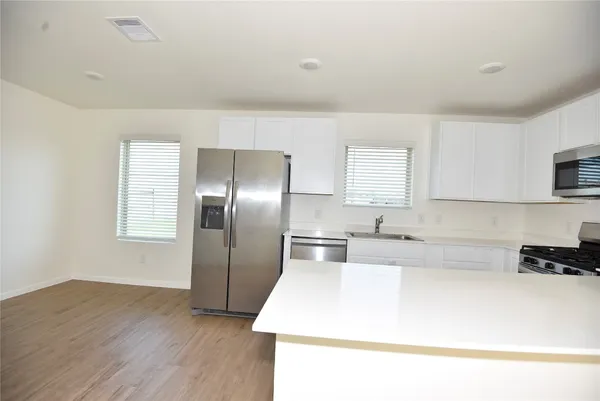 a kitchen with kitchen island a counter top a sink and a stove