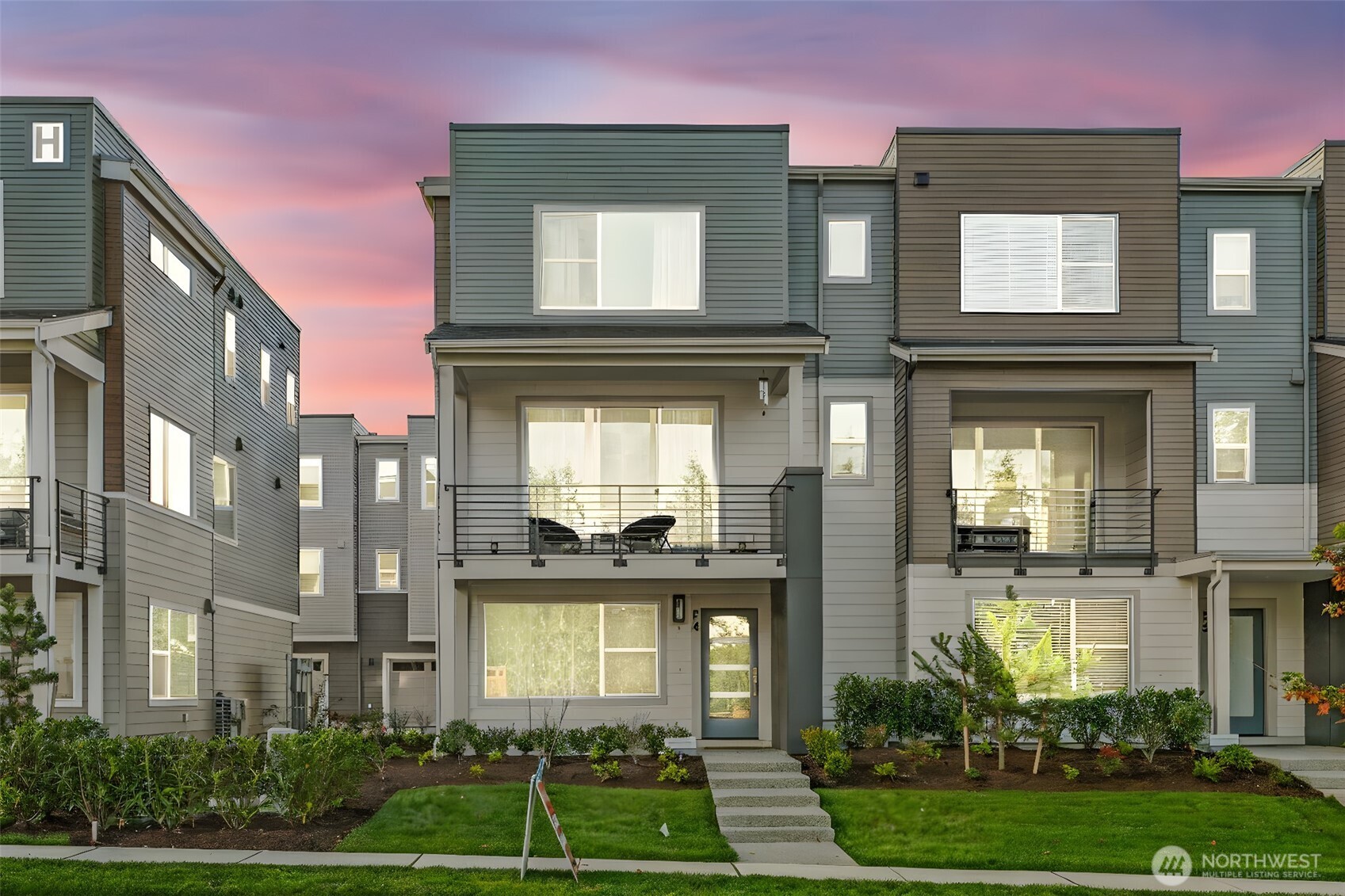 a front view of a residential apartment building with a yard