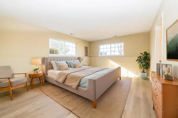 a spacious bedroom with a bed and a flat screen tv