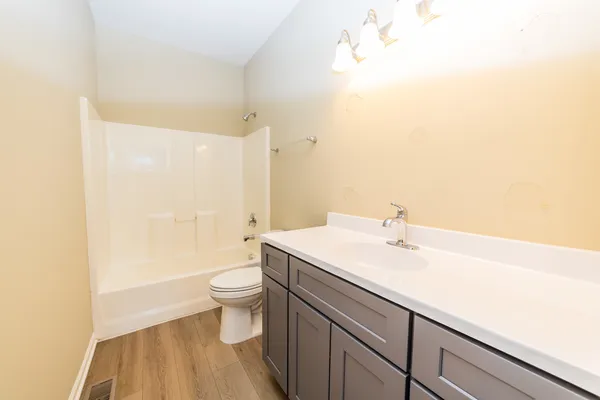 a bathroom with a sink a toilet and a large mirror