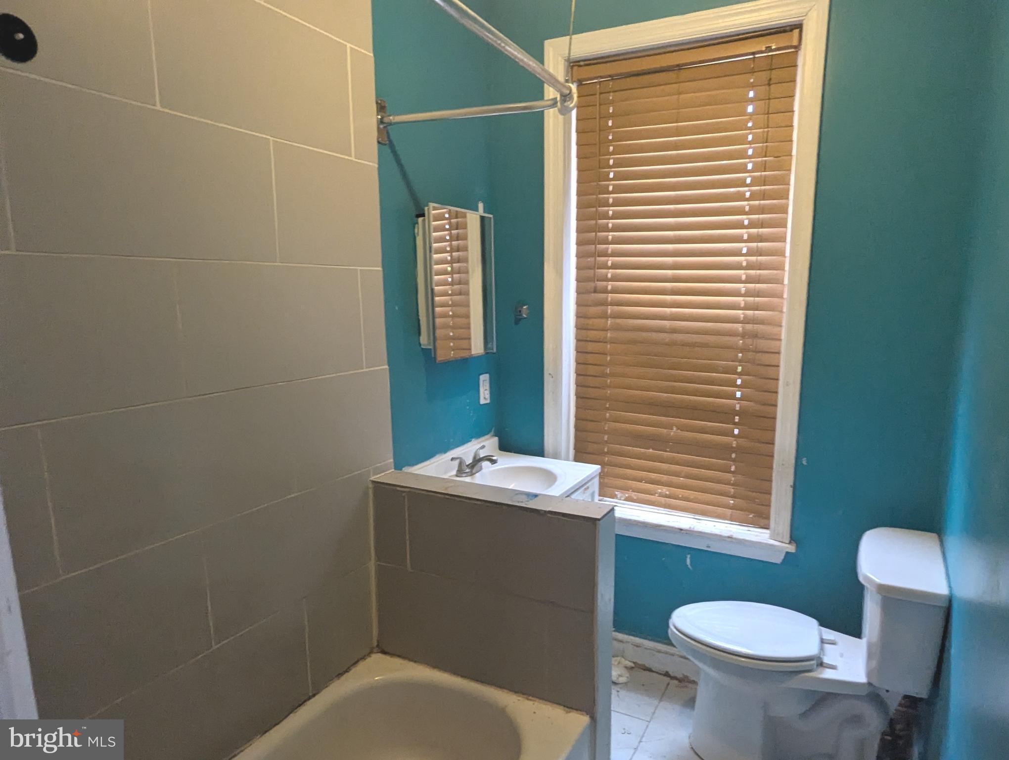 3838 Cambridge Street Philadelphia, PA 19104 - Photo 3 of 10 a bathroom with a toilet a sink and mirror