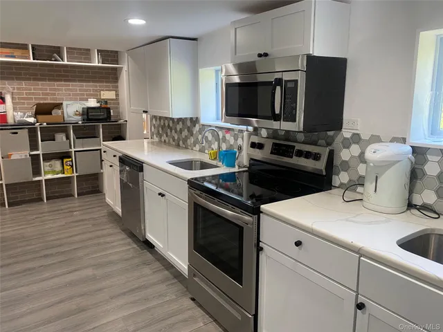 a kitchen with a sink appliances and cabinets