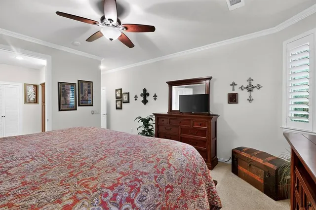 a bedroom with a bed a dresser and a flat screen tv